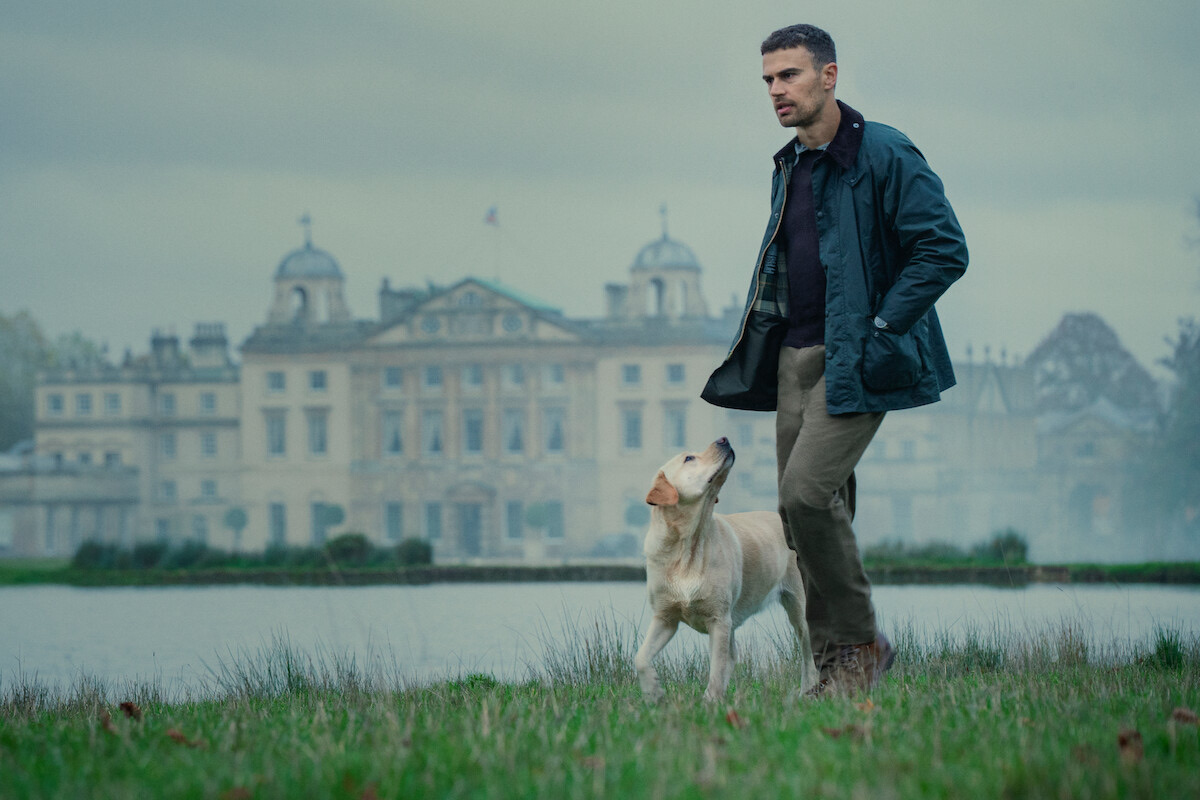 Eddie Horniman — Theo James as Eddie Horniman walks near a body of water with a large estate in the background in Season 1 of ‘The Gentlemen’