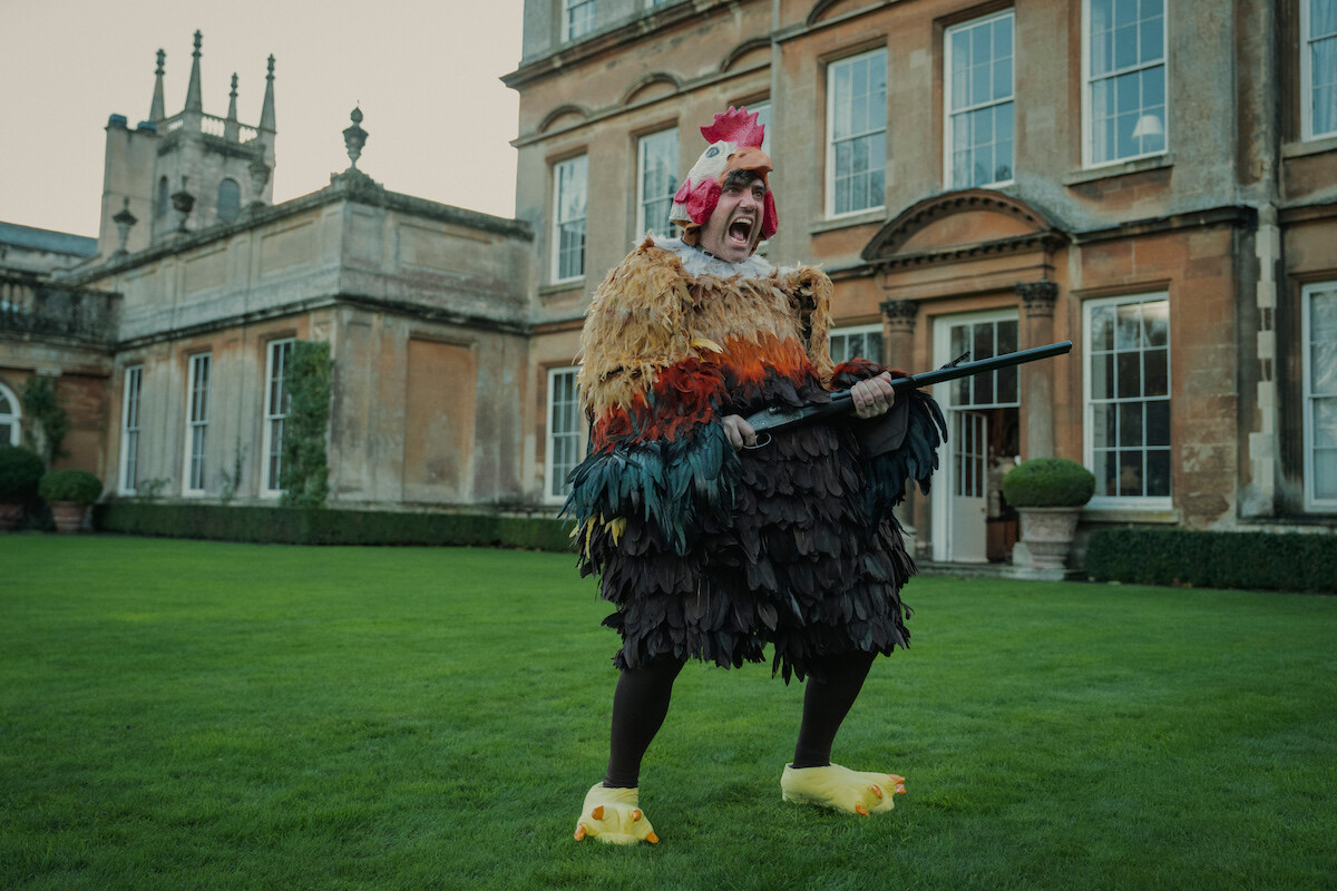 Freddy Horniman — Daniel Ings as Freddy Horniman wears a chicken costume and holds a shotgun in Season 1 of ‘The Gentlemen’