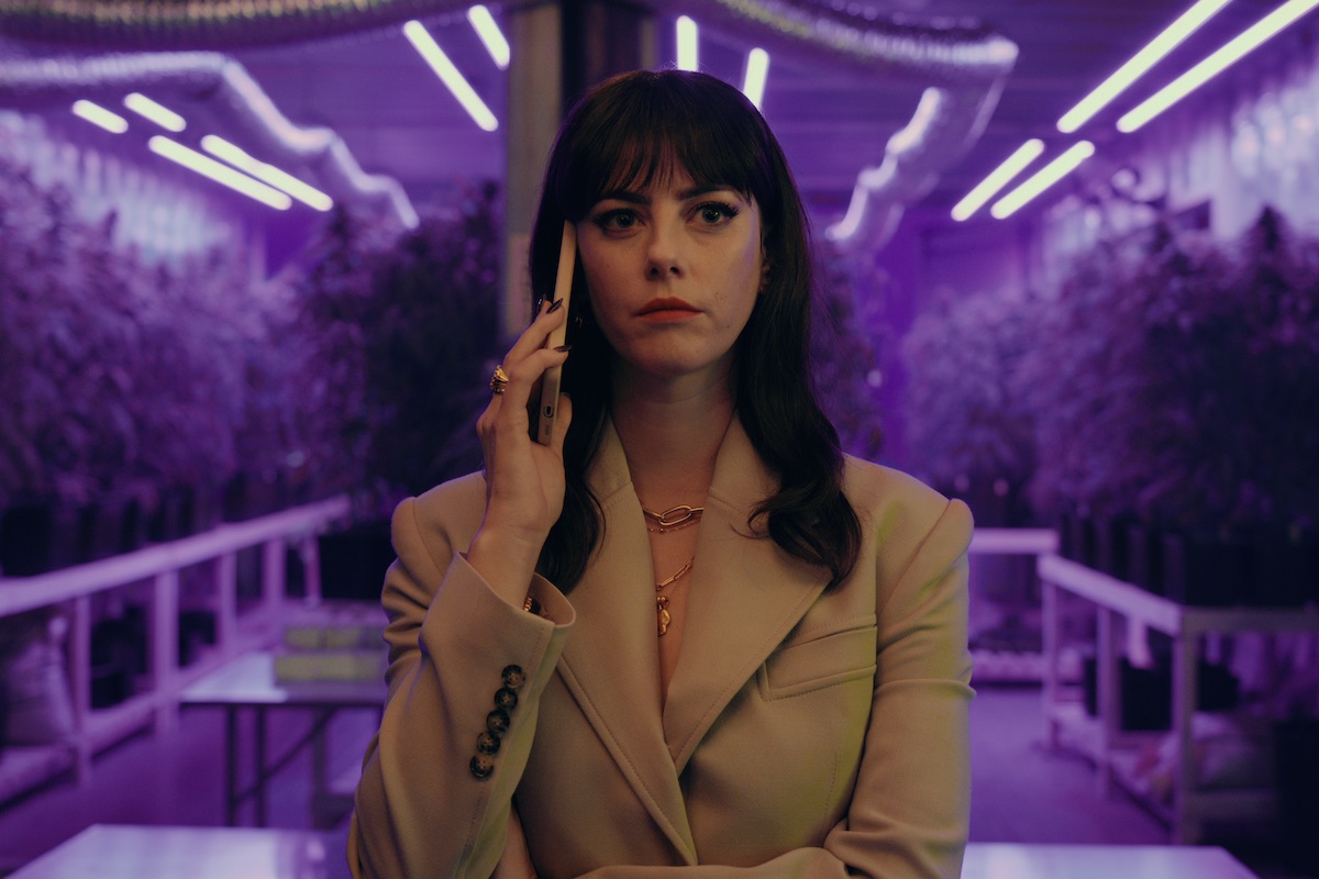 Susie Glass — Kaya Scodelario as Susie Glass takes a phone call in a room with marijuana growing in Season 1 of ‘The Gentlemen’